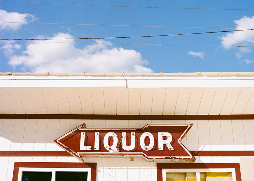 Fotografia vintage szyld 'LIQUOR' na niebieskim niebie